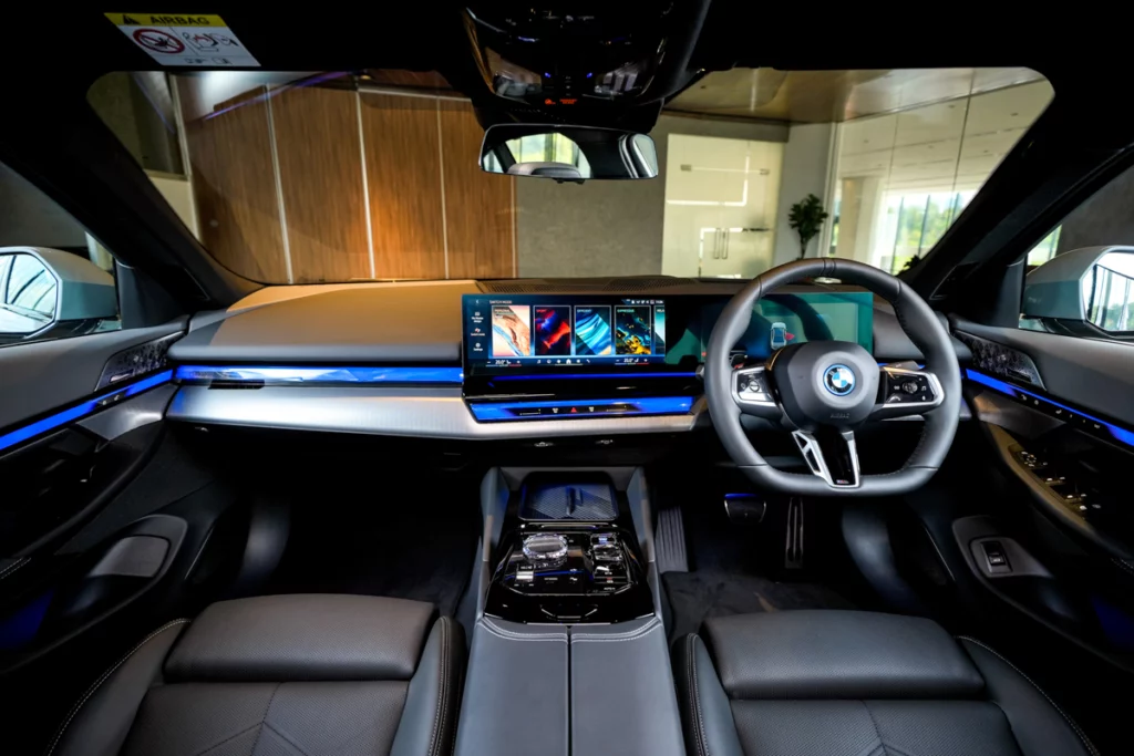 BMW i5 M60車內駕駛席和中控台的豪華內裝,展示了其先進的多功能顯示屏和精緻的細節