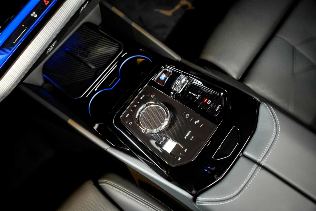 BMW i5 M60車內中控台的豪華設計,展示換擋桿、多媒體控制旋鈕和精緻皮革縫線